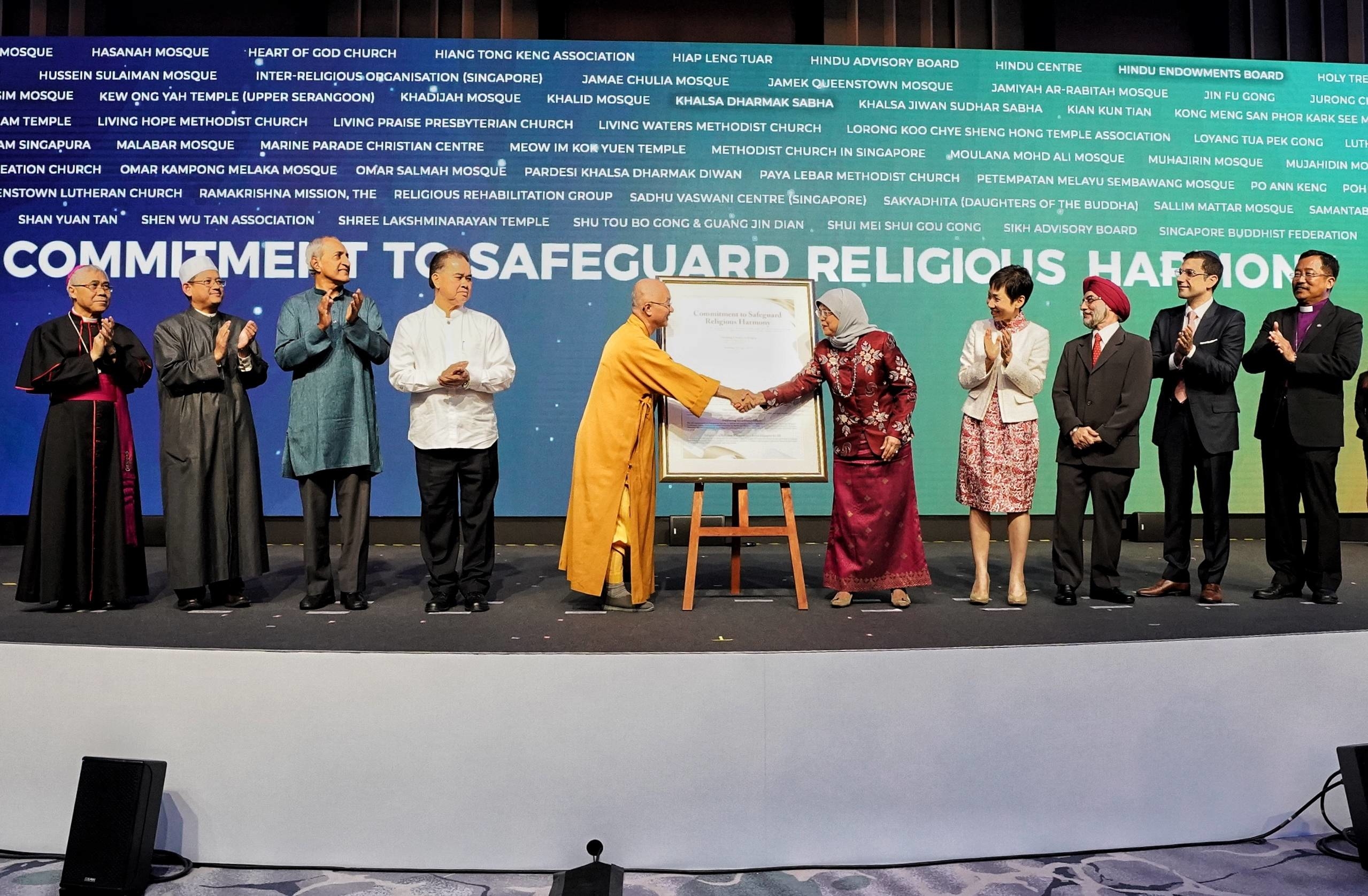 Venerable Seck Kwang Phing presenting a commemorative version of the Commitment to Safeguard Religious Harmony to Former President Halimah Yacob on behalf of Singapore's National Steering Committee at ICCS 2019 on 19 June 2019. (Photo: MCCY)